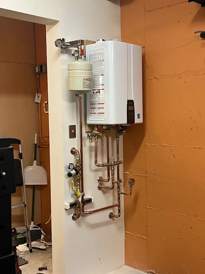 Plumbing technician inspecting water heater connections in The Woodlands